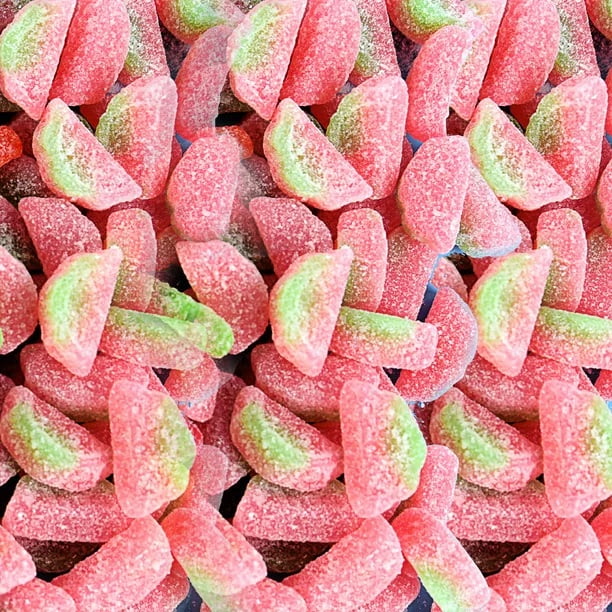 Close-up of gummy watermelon slices in red, green, and pink.