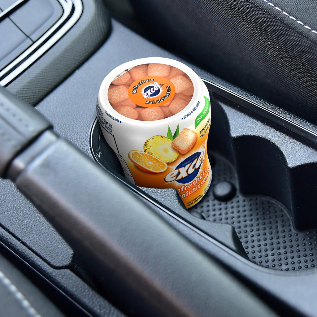 Excel Sugar-Free Gum, Refreshers Tropical, 6 ct. Package, one bottle in a cup holder in a car.