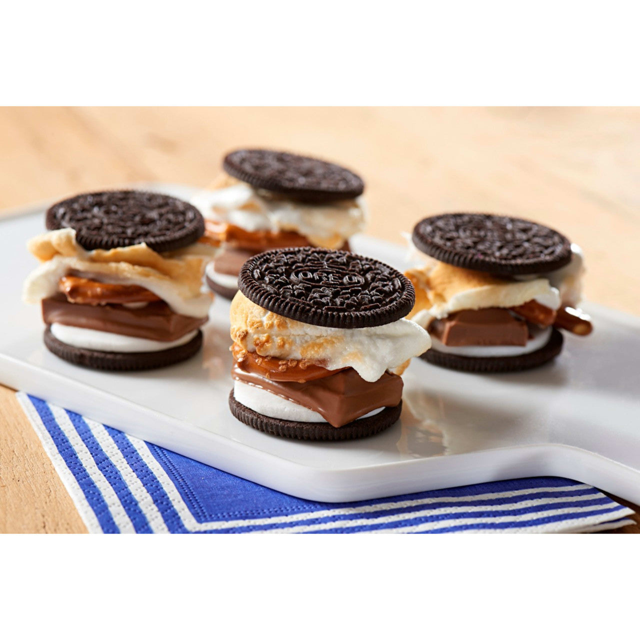 S'mores desserts made with Oreo cookies on a cutting board with a beige background